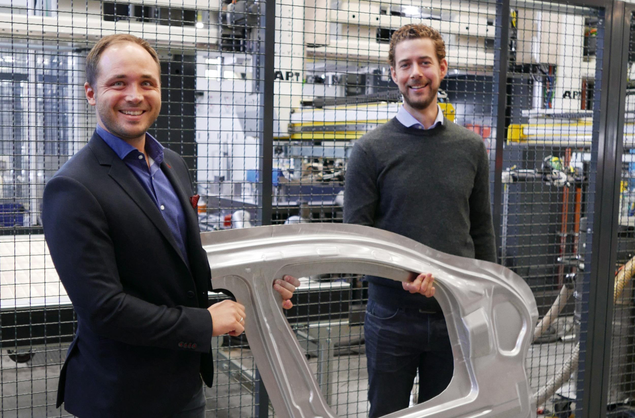 AP&T's Chief Technology Officer, Dr. Christian Koroschetz and Manager Development Forming Processes & Tooling, Dr. Michael Machhammer proudly display the complex-shaped door ring component, exhibiting the typical door inner design elements.